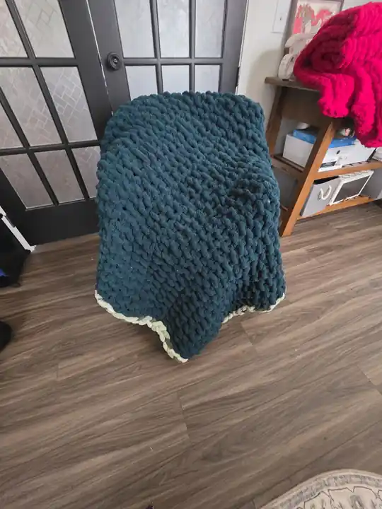 Customer-made teal chunky knit blanket with a cream edge