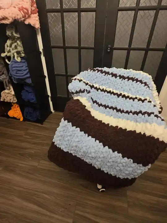 Customer-made chunky knit blanket with brown, white, and blue stripes